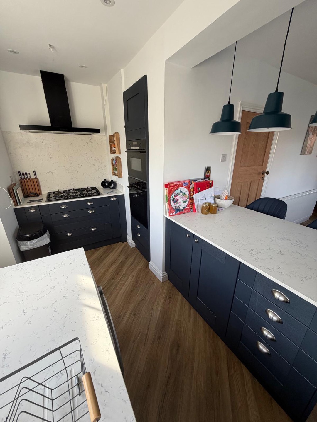 Navy shaker kitchen with marble-effect quartz worktops and matt black extractor